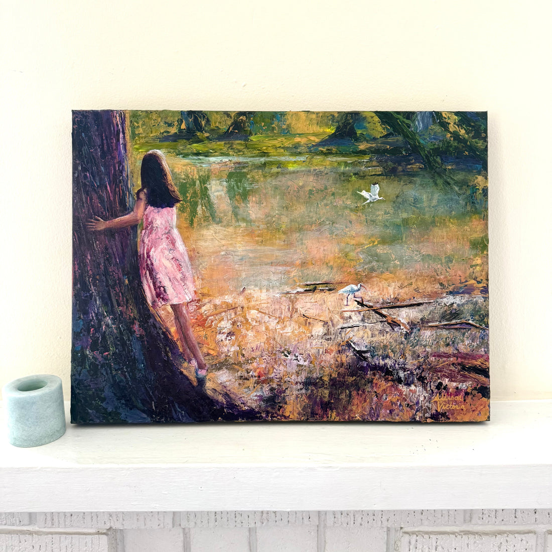 Textured acrylic palette knife painting of a young girl in a pink dress standing by a tree, watching birds over a reflective body of water.