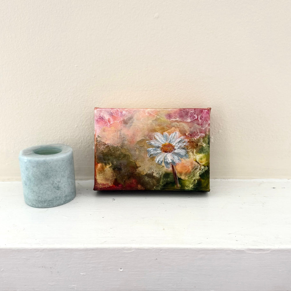 Small floral painting on a white surface with a plain background