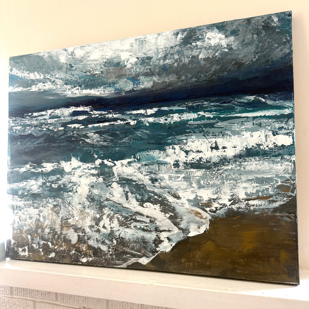 Abstract acrylic palette knife painting of ocean just before a storm with blue, white, and brown tones on a beige wall and mantle