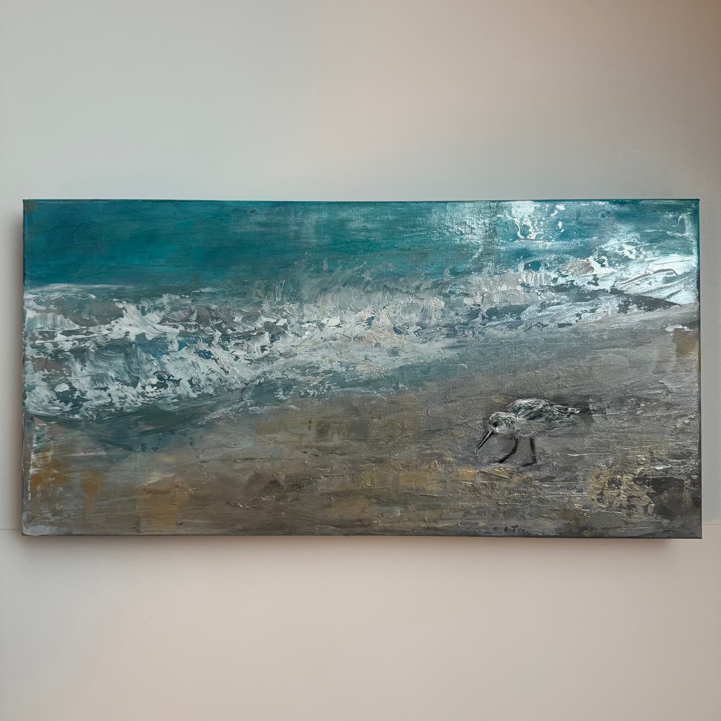 Abstract painting of shoreline ocean teal gray silver and gold with earthy tones on a plain wall with sandpiper beach bird acrylic palette knife painting thick texture